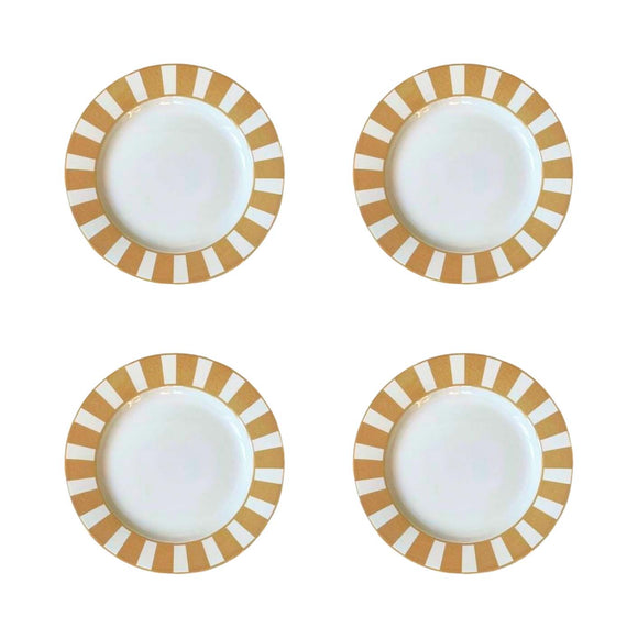 Four white plates with gold and white striped rims on a white background